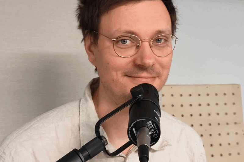 Foto von Nils Sommer vor einem Podcastmikrofon