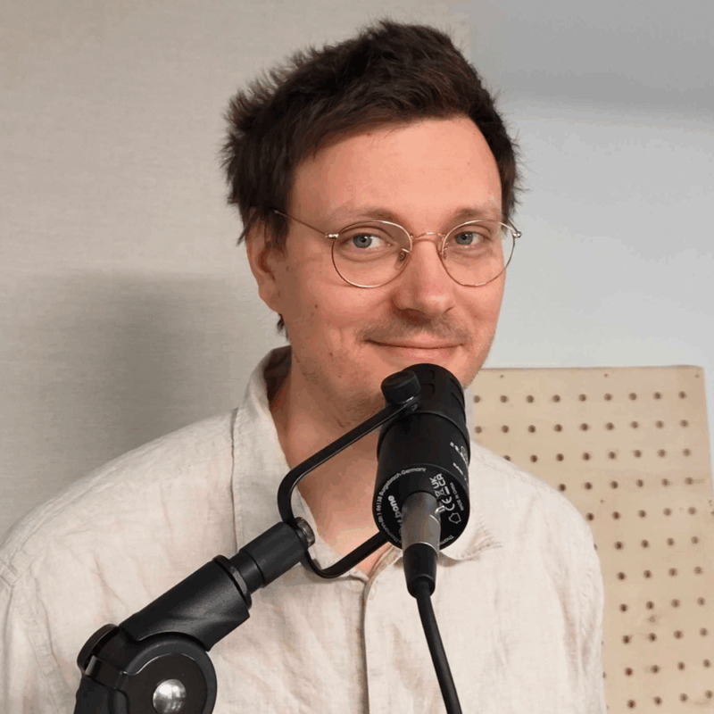 Foto von Nils Sommer vor einem Podcastmikrofon